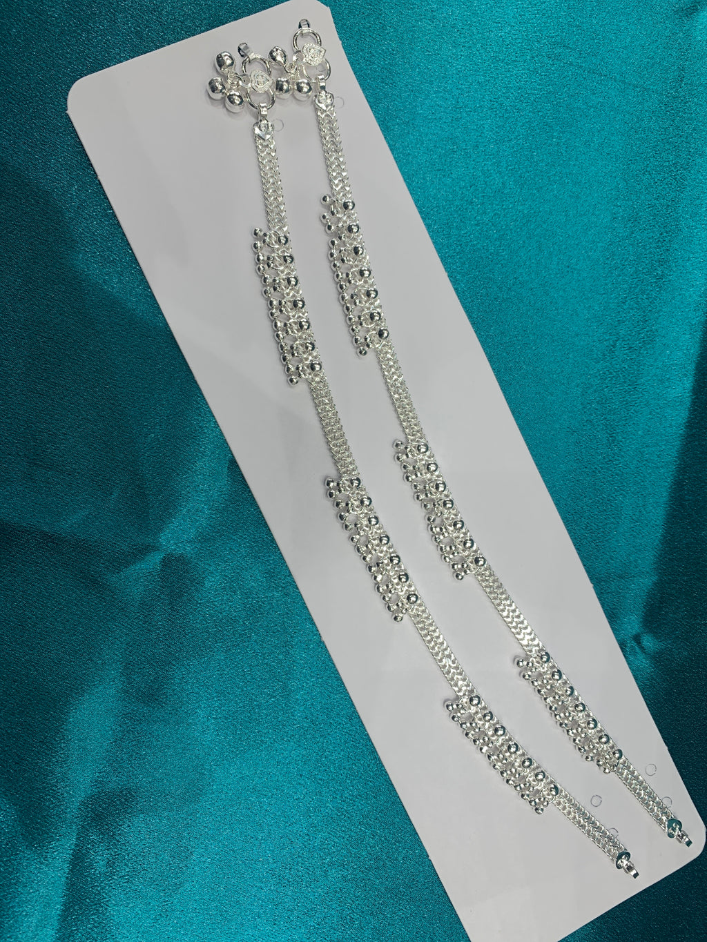 Traditional silver anklets with hanging bells in sequence