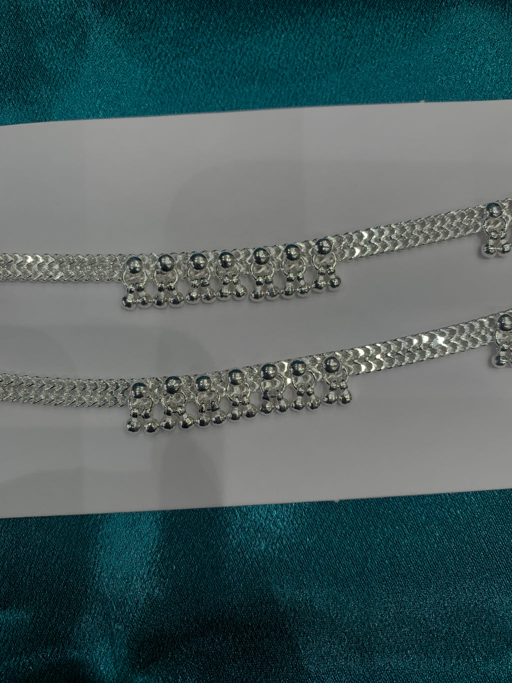 Traditional silver anklets with hanging bells in sequence