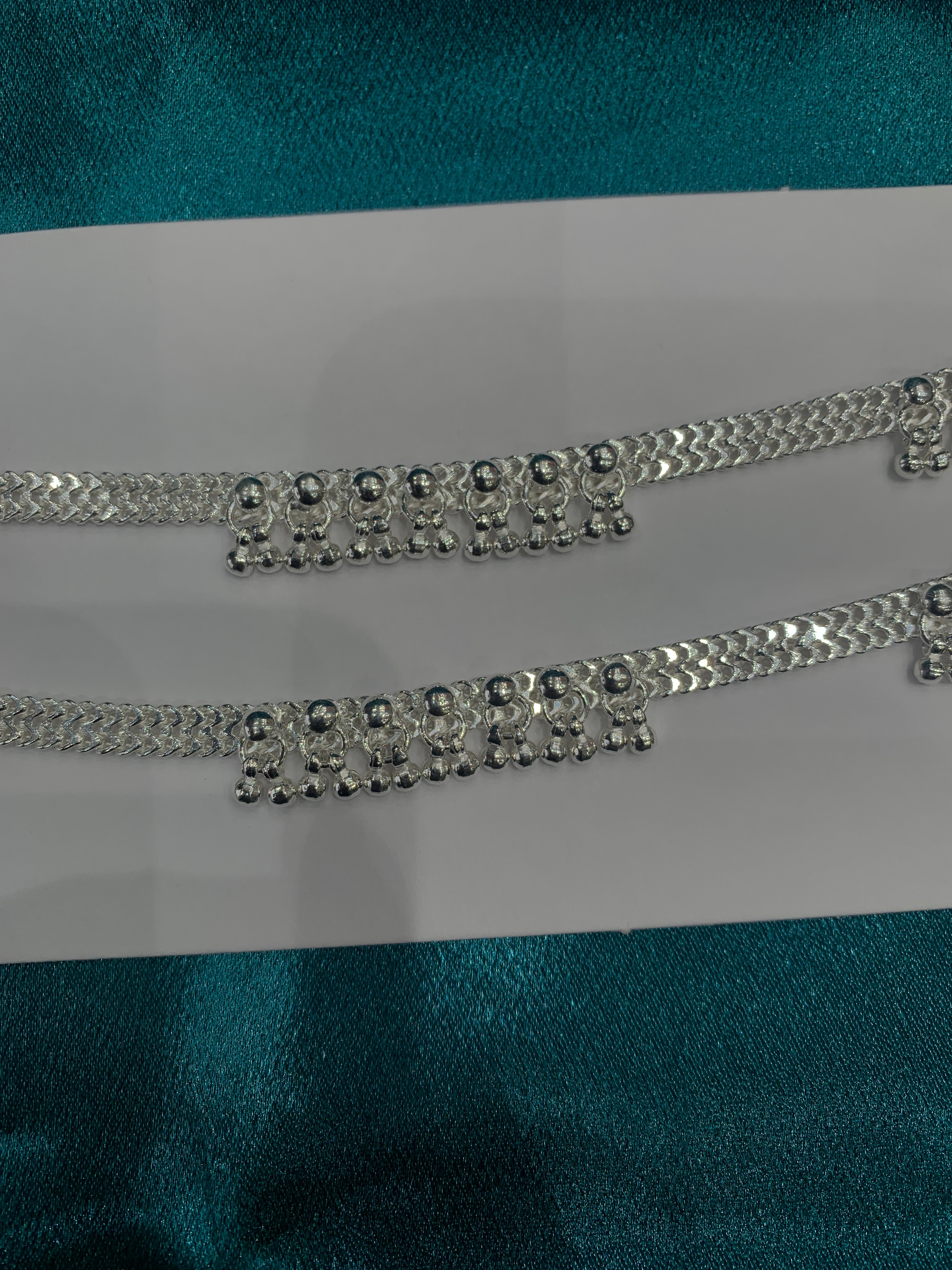 Traditional silver anklets with hanging bells in sequence