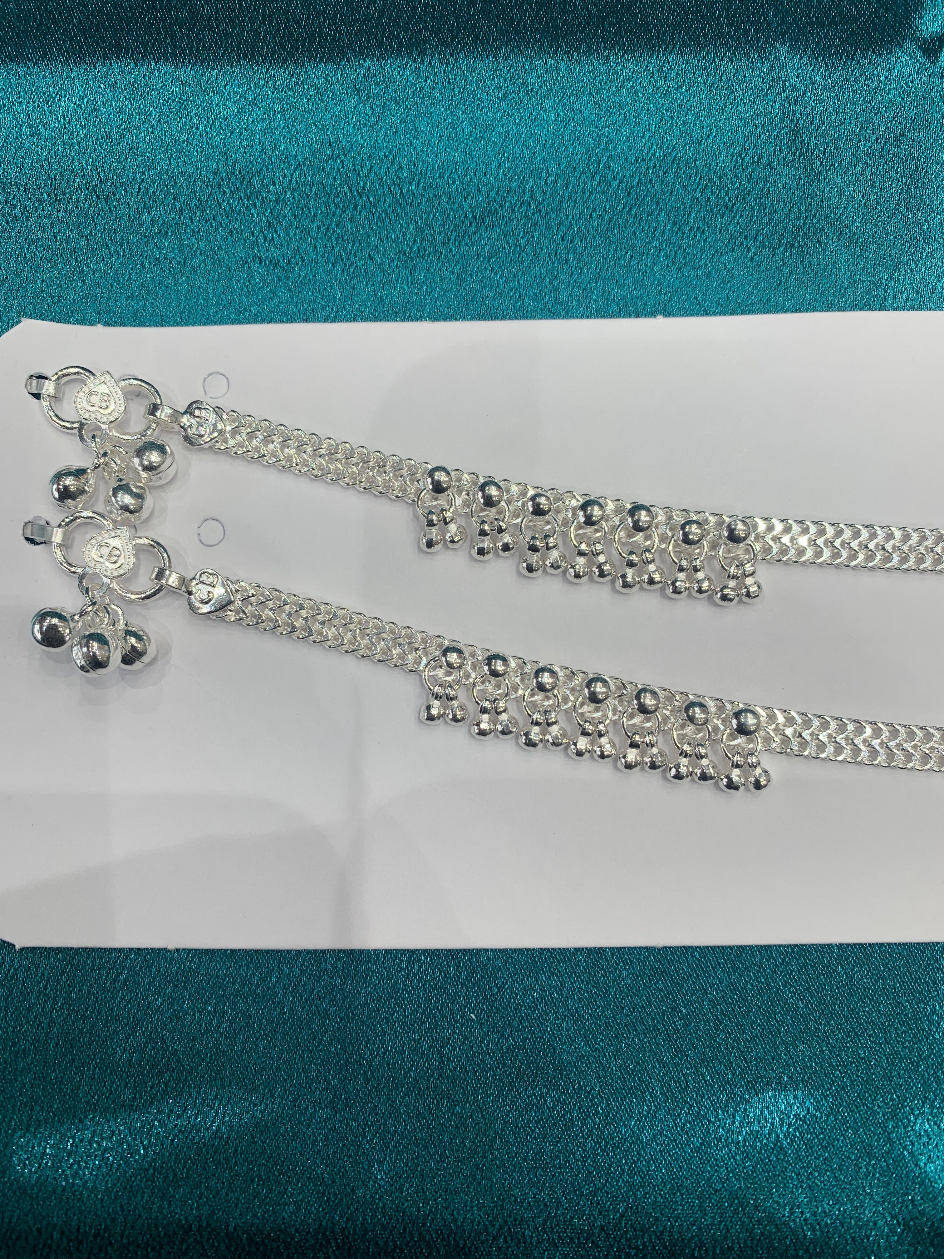 Traditional silver anklets with hanging bells in sequence