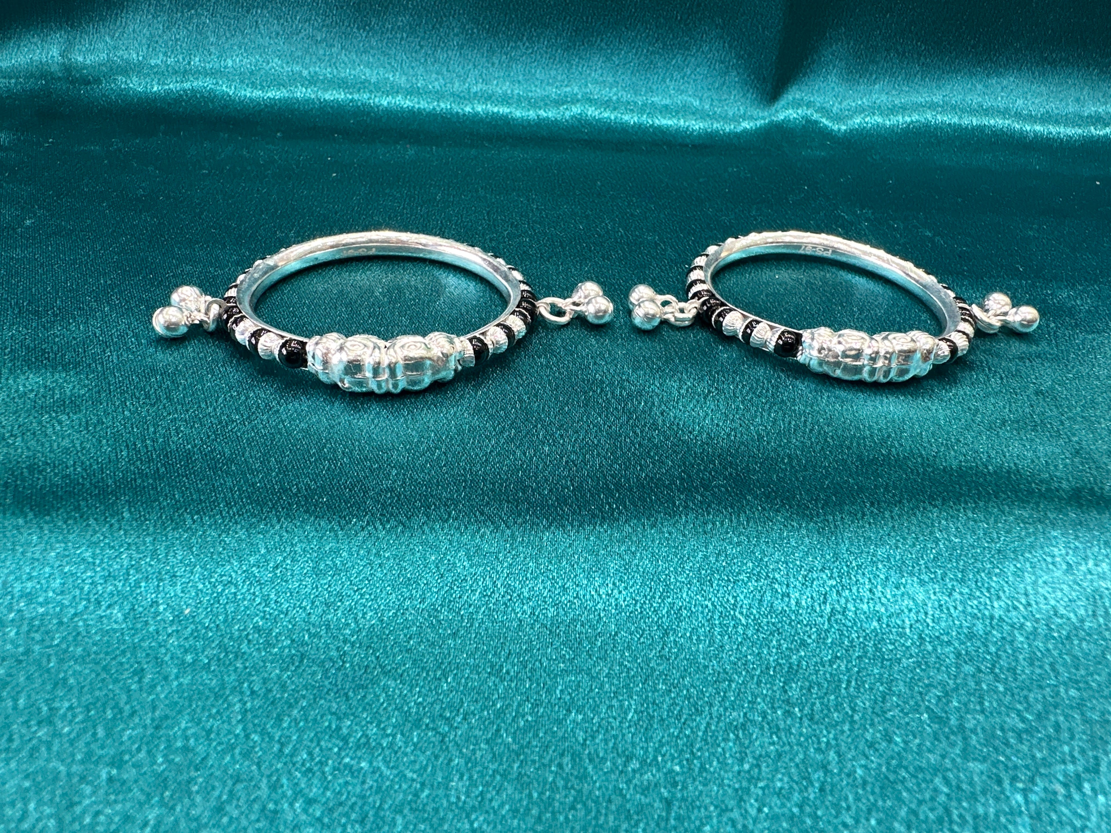 Silver baby bangles with black beads and bells
