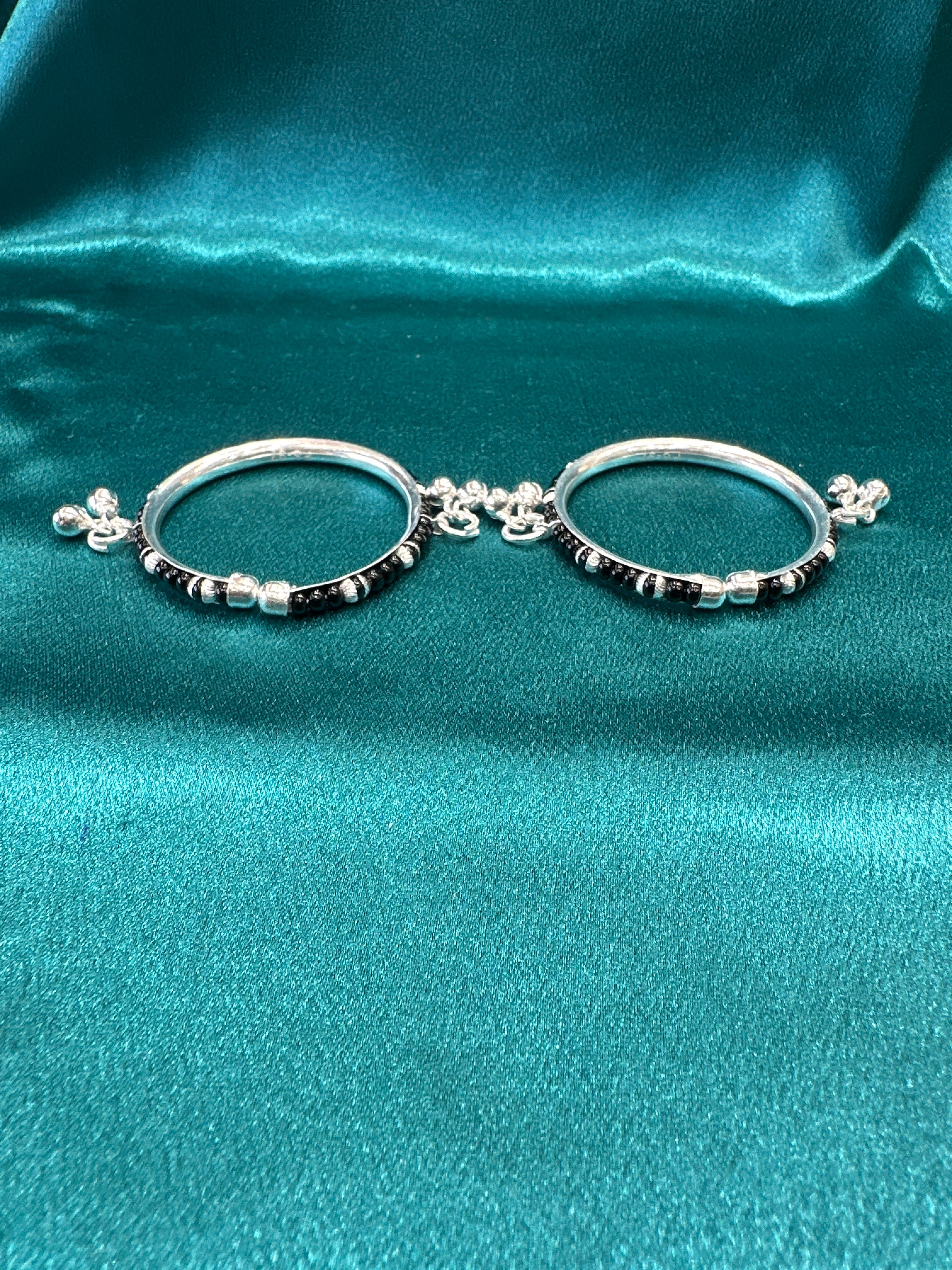 Silver baby bangles with black beads and bells