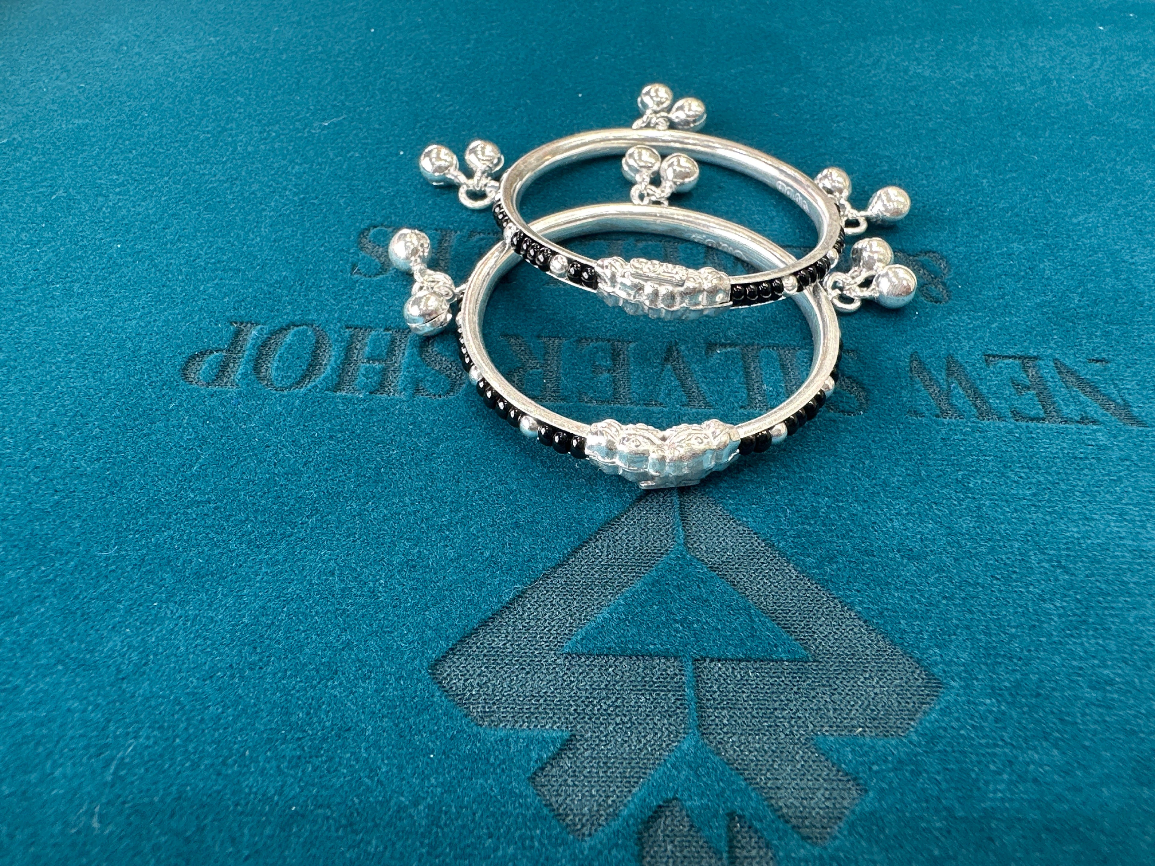 Silver baby bangles with black beads and bells
