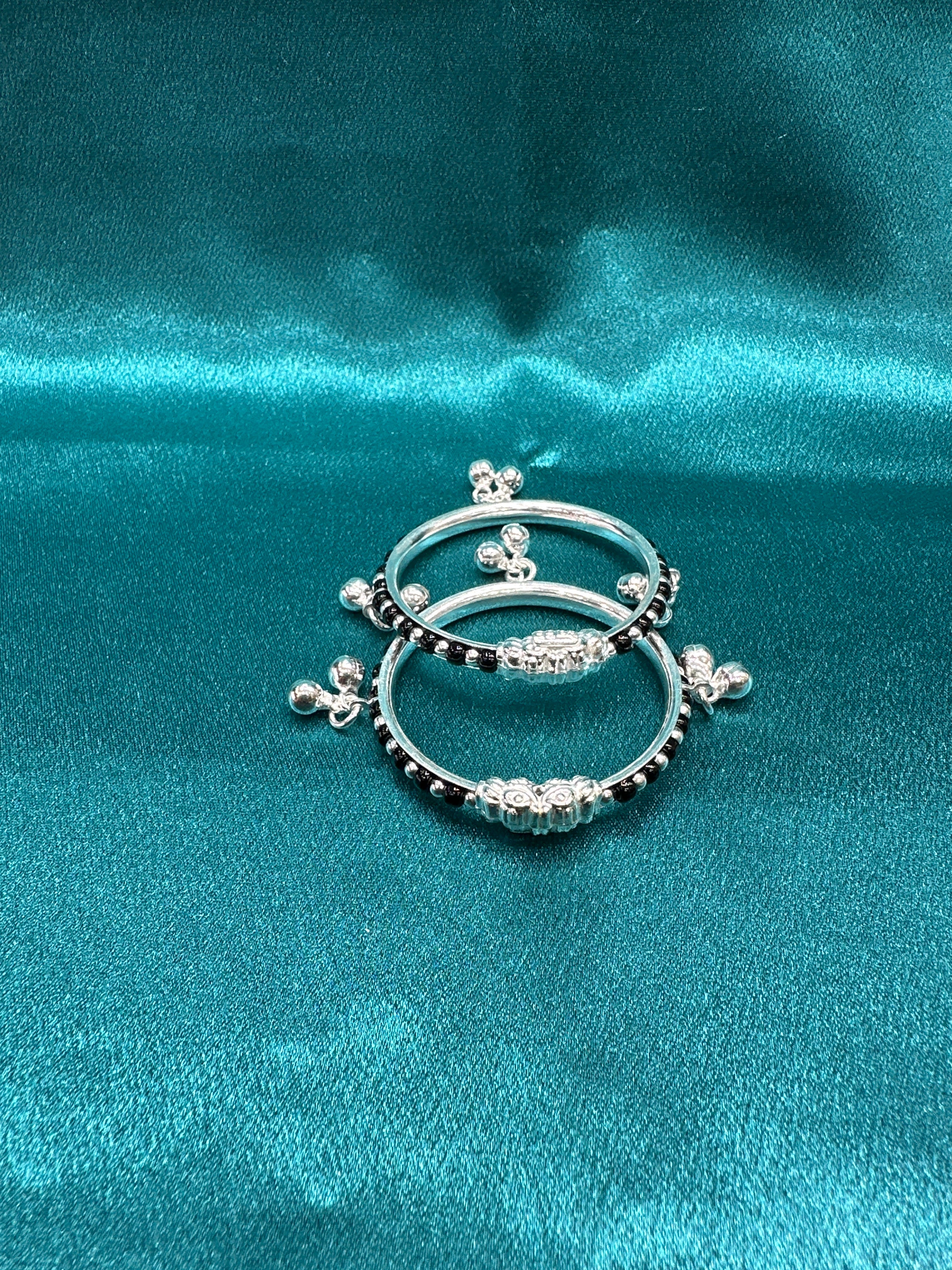 Silver baby bangles with black beads and bells