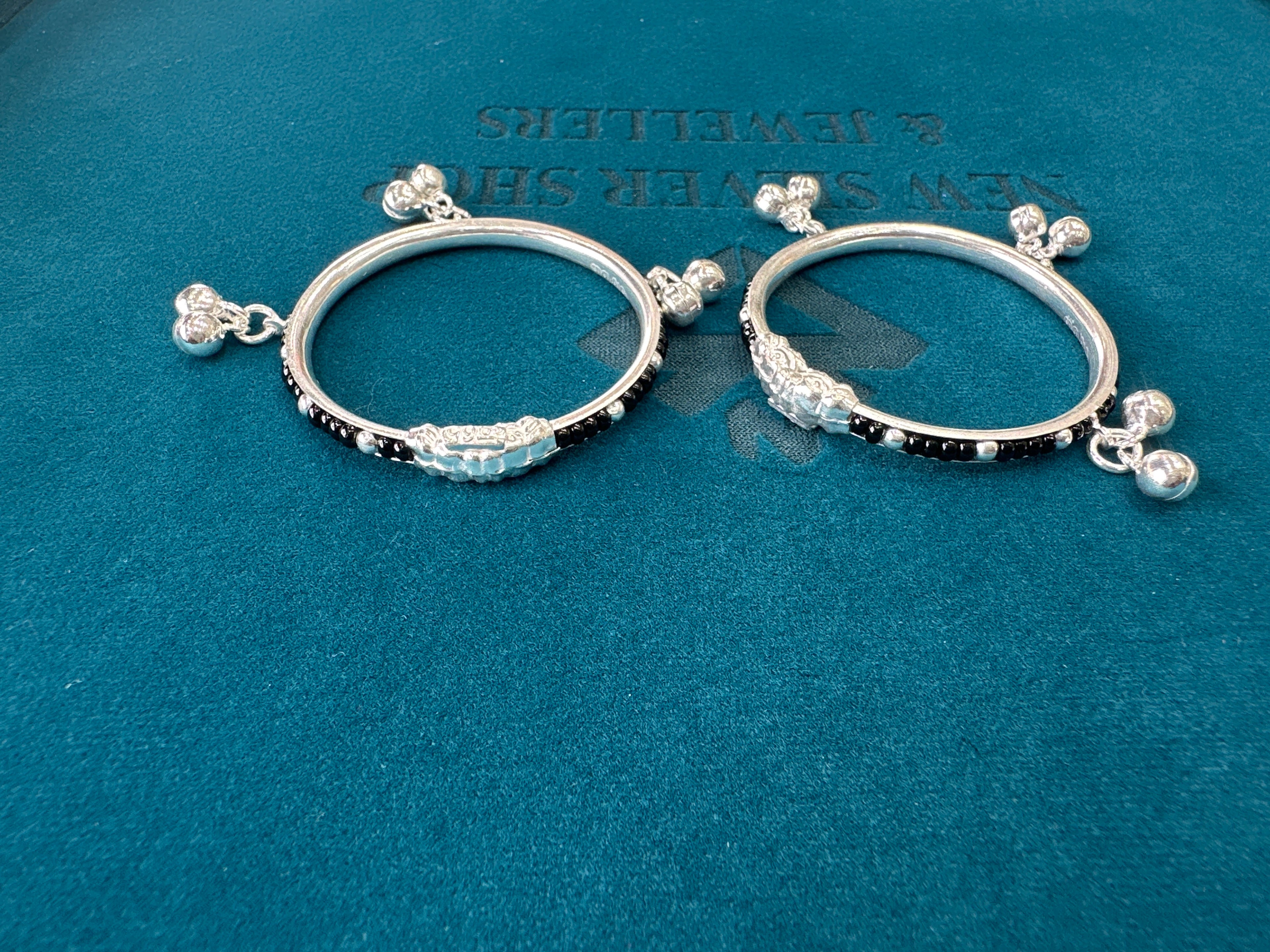 Silver baby bangles with black beads and bells