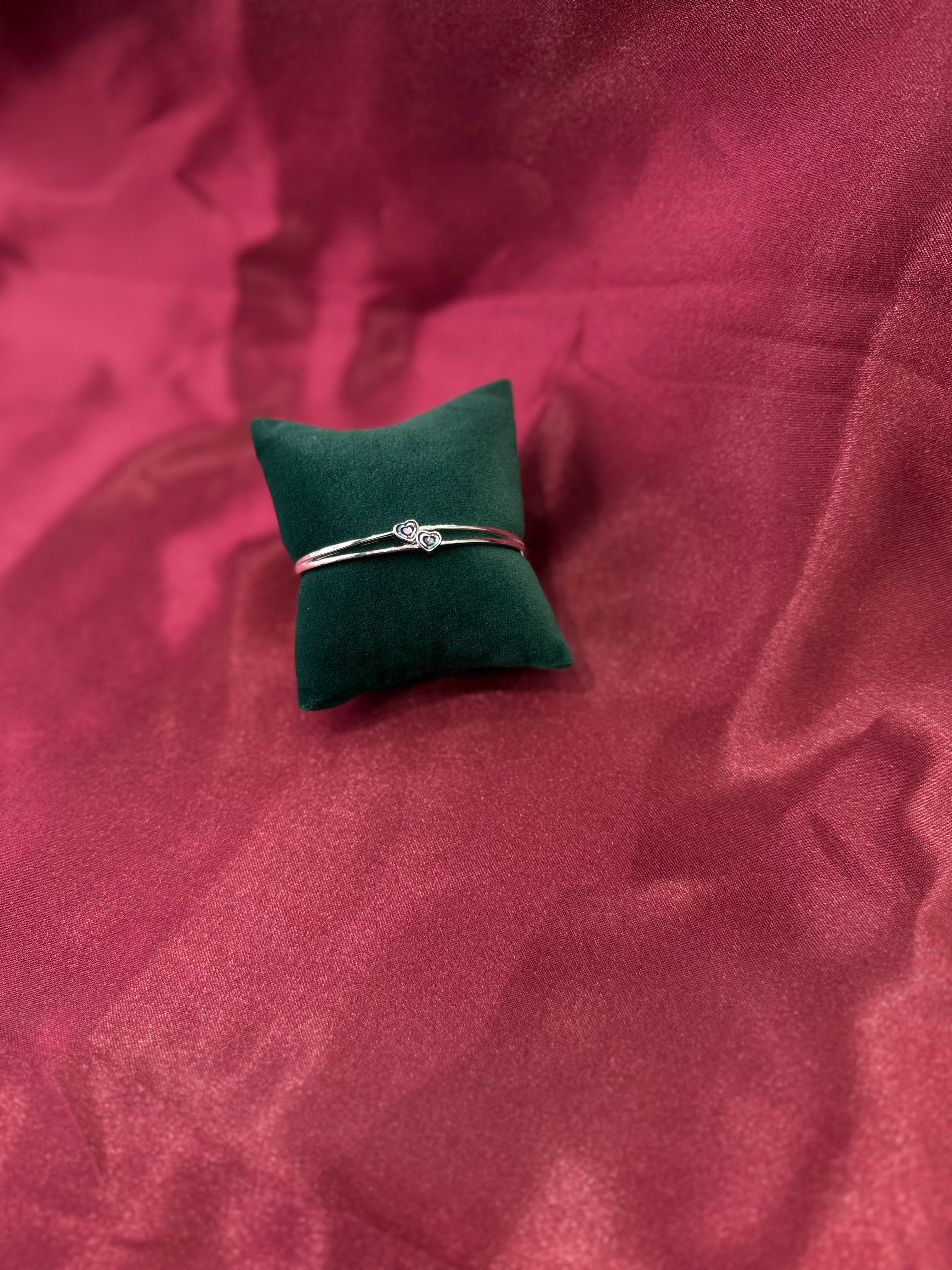 Fancy silver bangle with tiny twin hearts