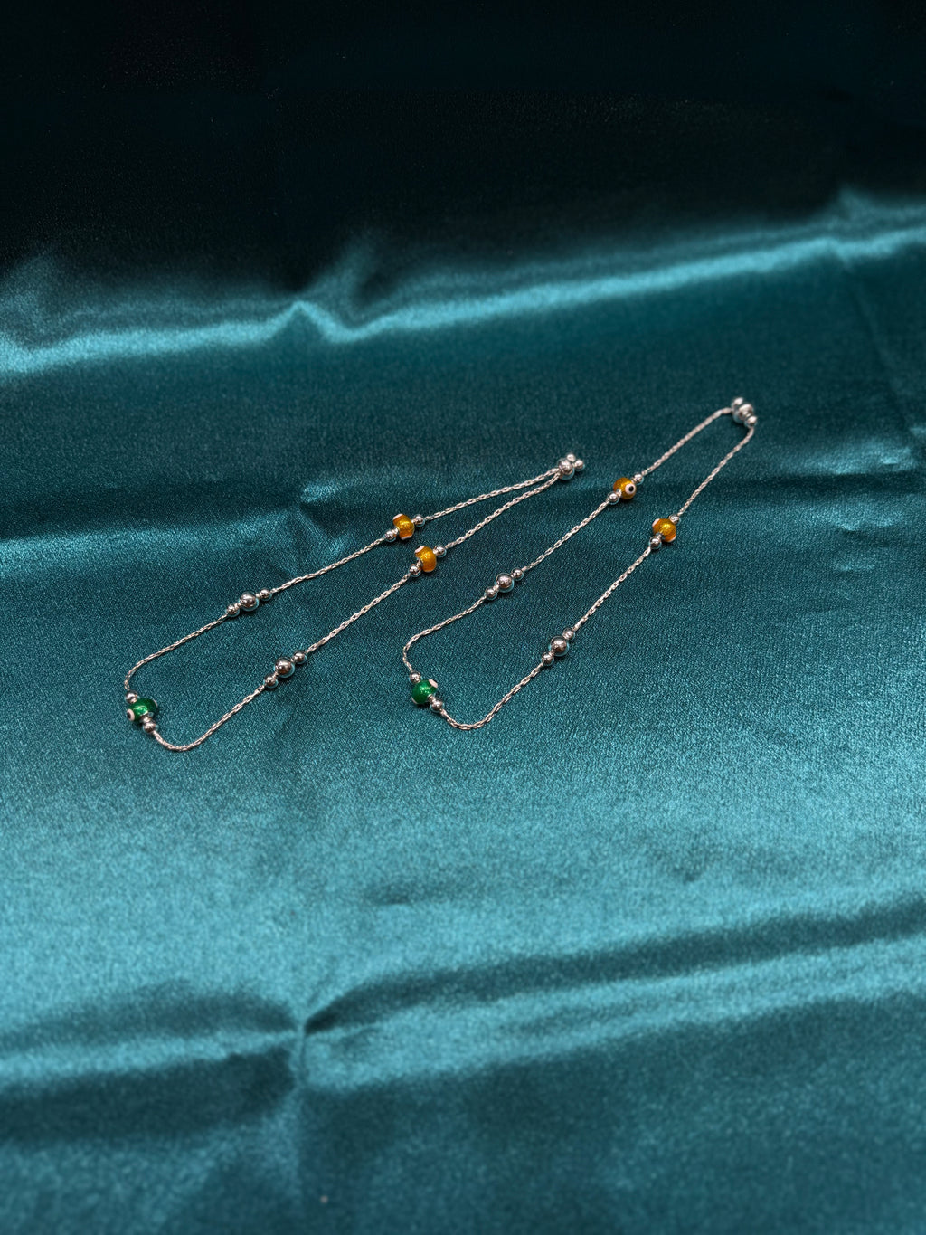 Fancy silver anklet with green and yellow evil beads