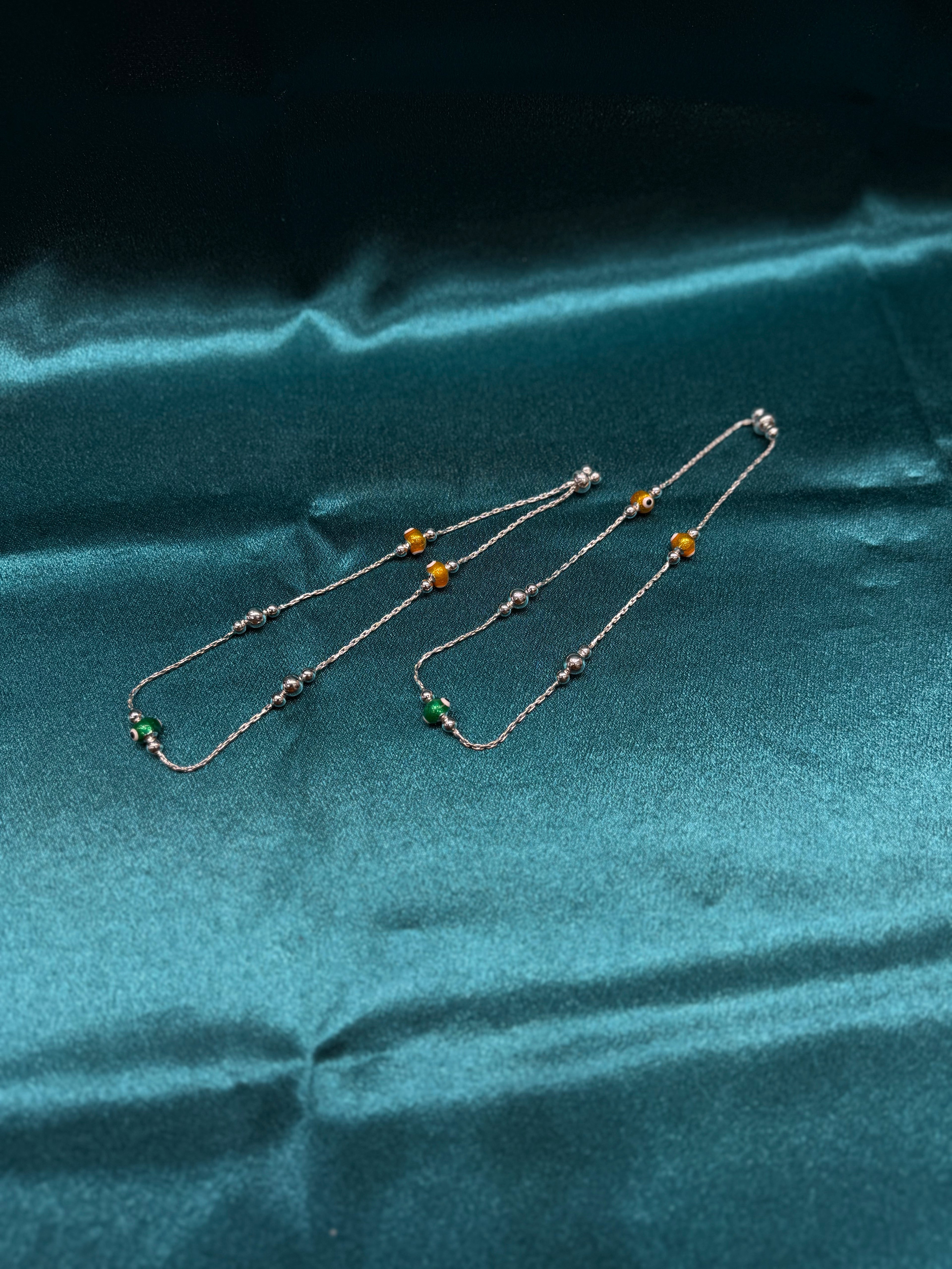 Fancy silver anklet with green and yellow evil beads