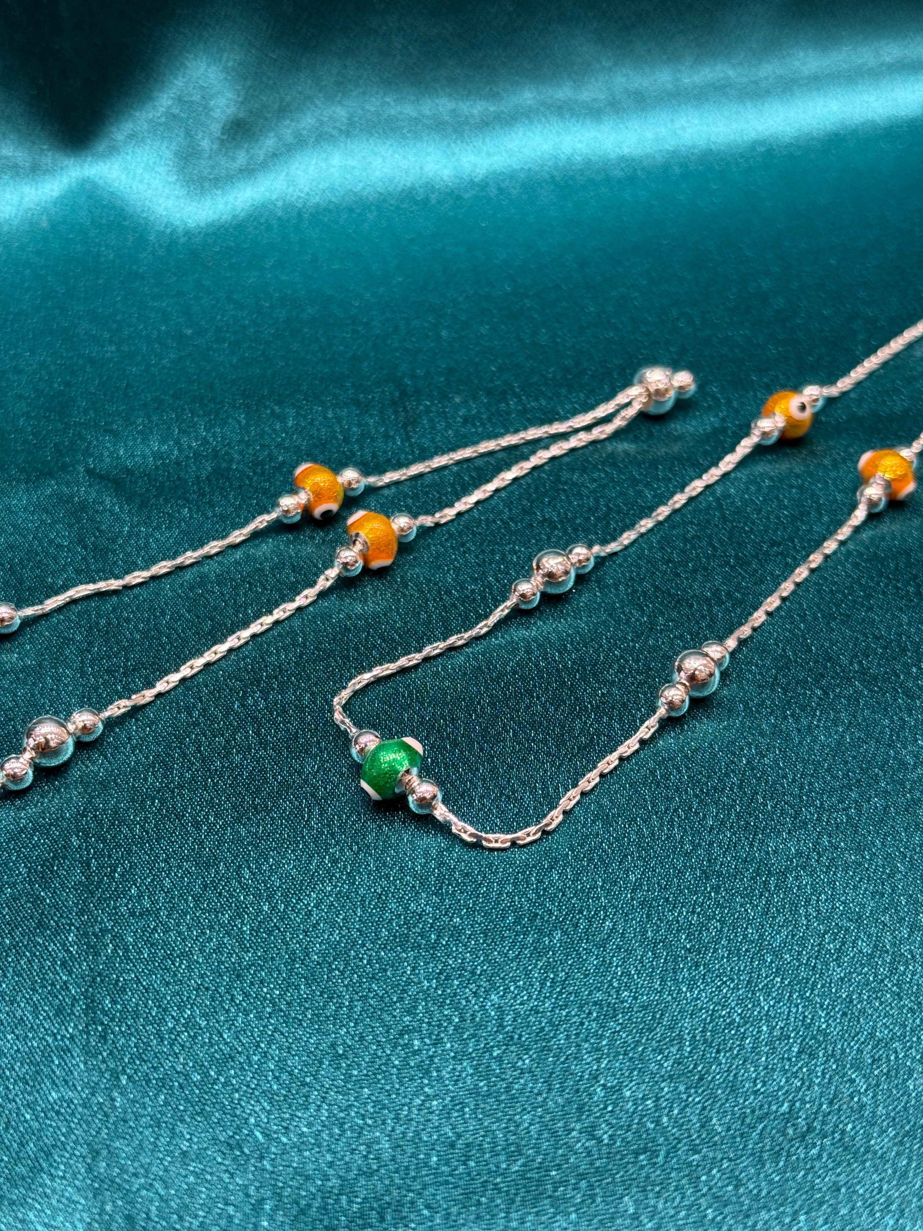 Fancy silver anklet with green and yellow evil beads