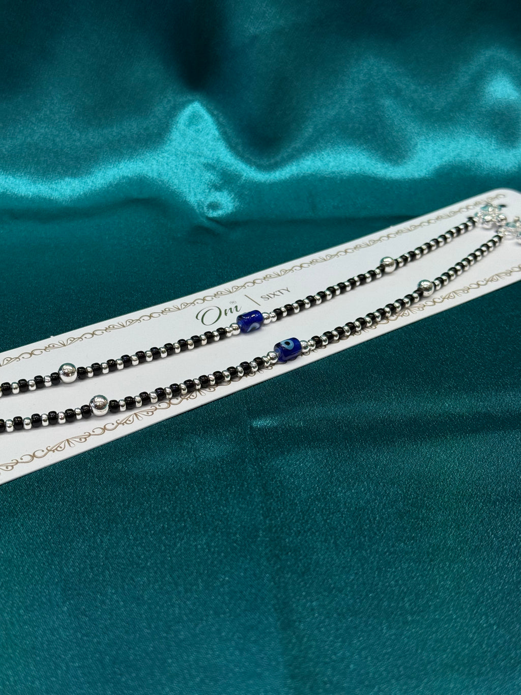 Fancy silver anklet with black, silver and blue evil eye