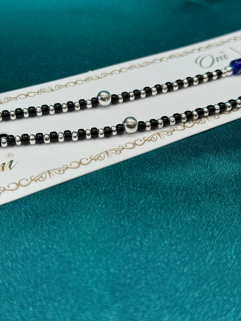 Fancy silver anklet with black, silver and blue evil eye