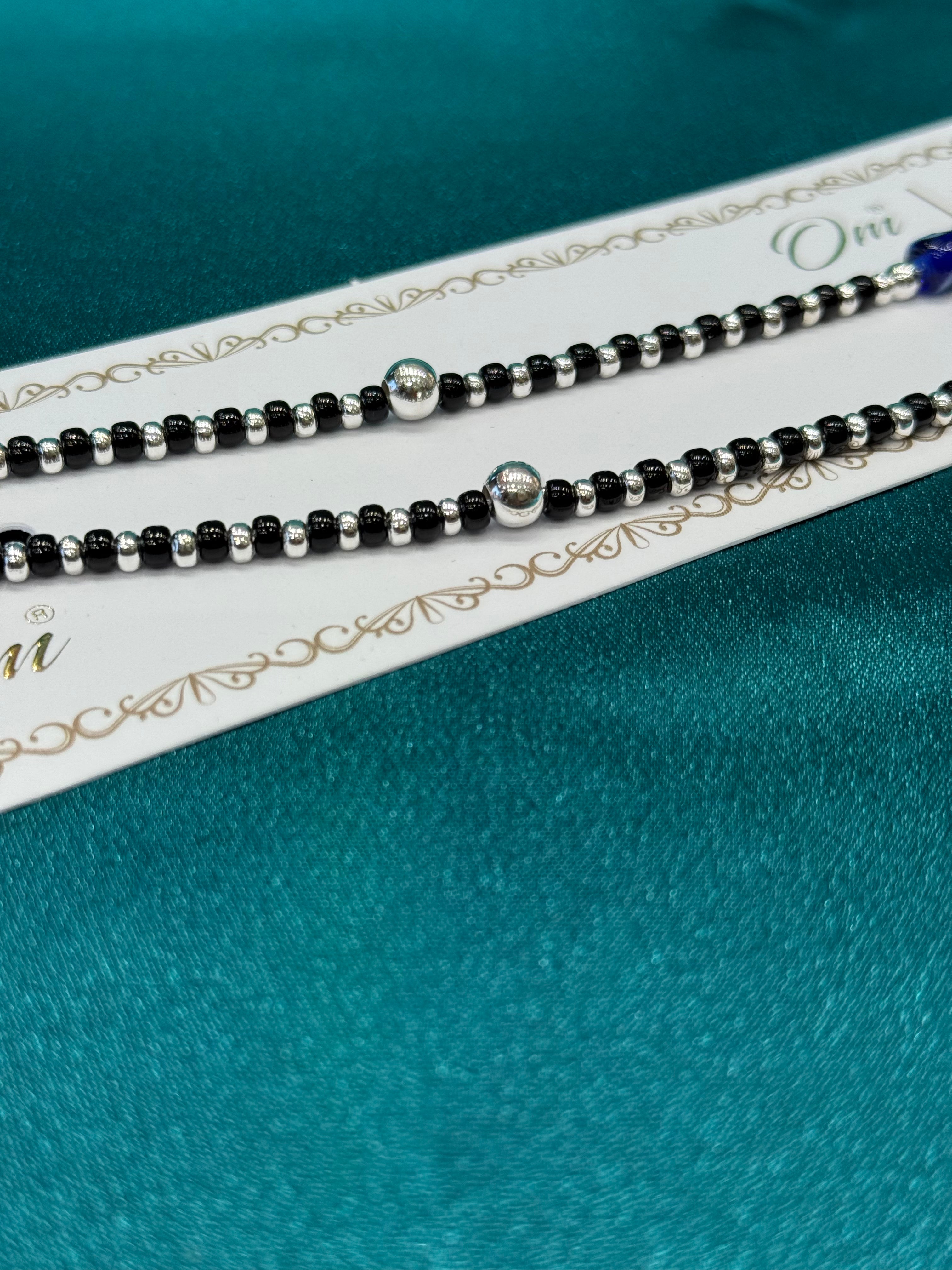 Fancy silver anklet with black, silver and blue evil eye