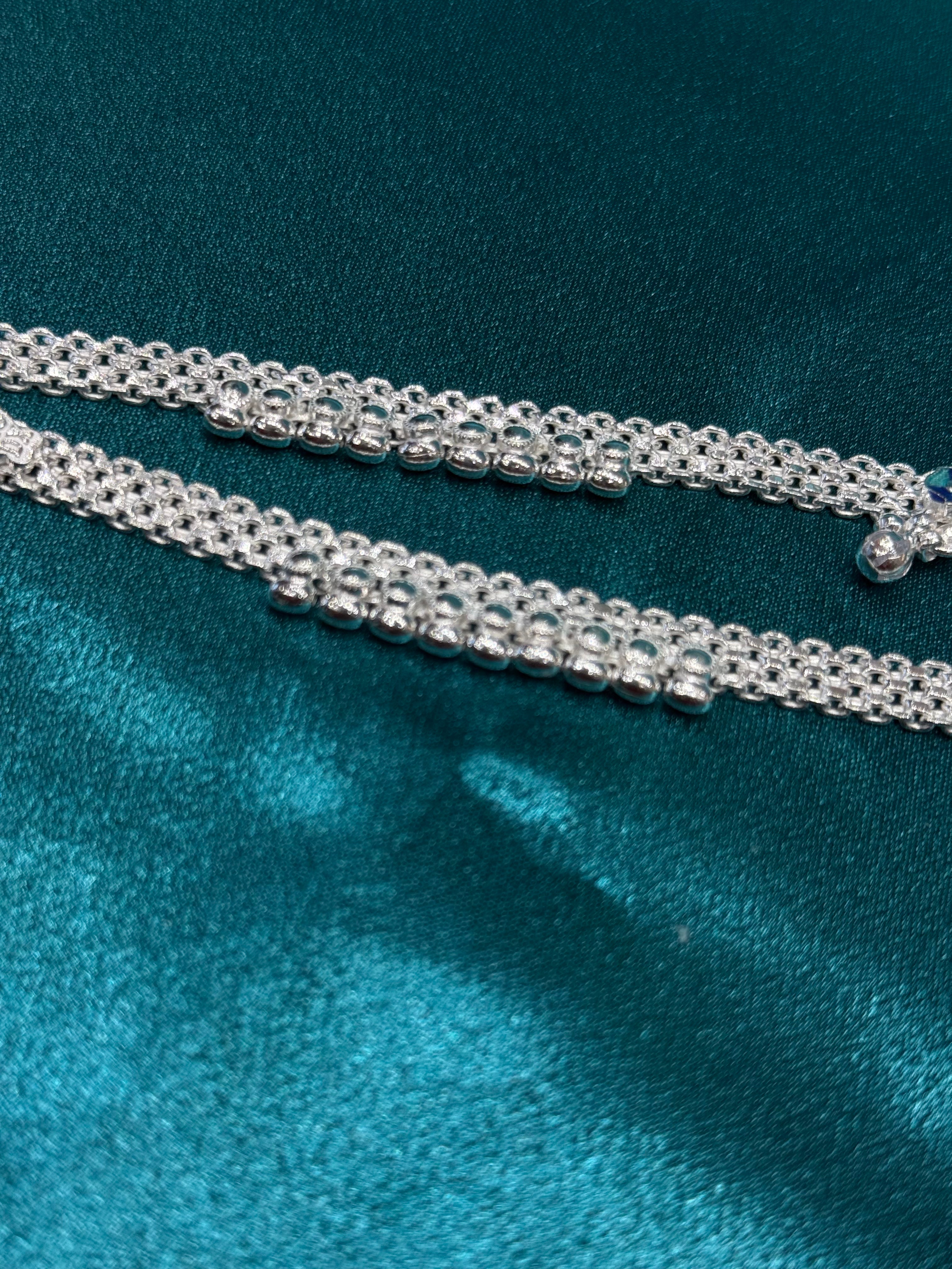 Traditional style silver anklets with hanging bells in middle