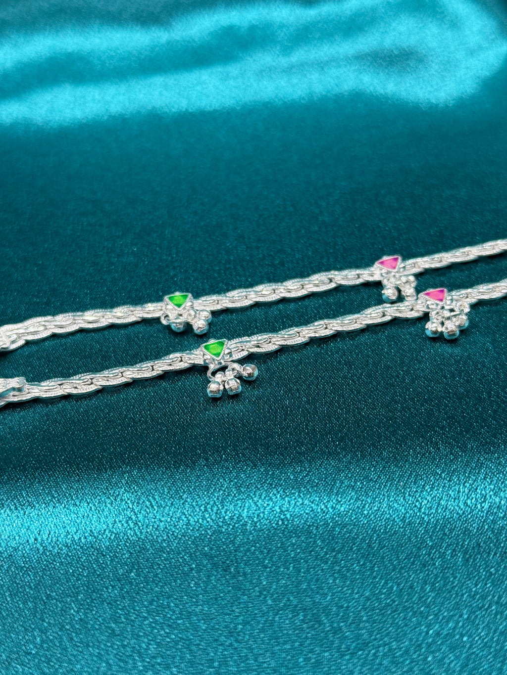 Traditional style silver anklets with hanging bell charm with pink and green triangle
